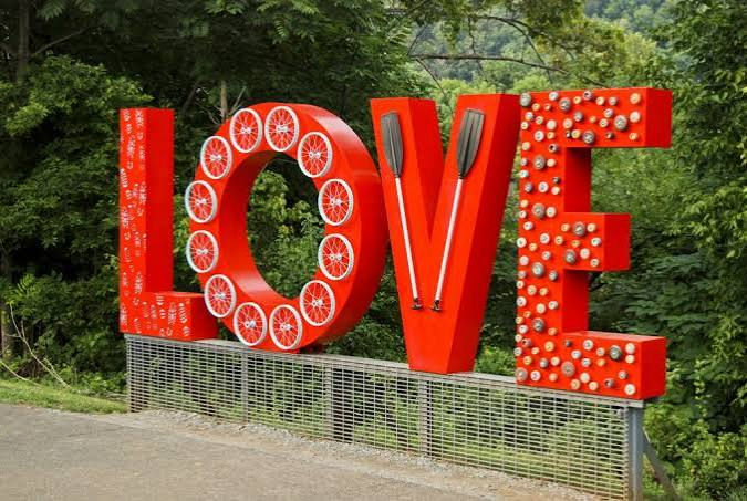 Red LOVE sign sculpture surrounded by trees at Percival's Island Natural Area in Lynchburg