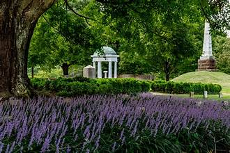 Purple salvia blooms in front of a white gazebo and historic monuments at Old City Cemetery in Lynchburg